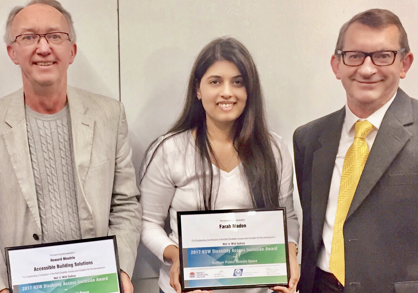 Photo of Howard Moutrie, Farah Madon receiving the 2017 NSW Access Award from FACS Director John Bailey